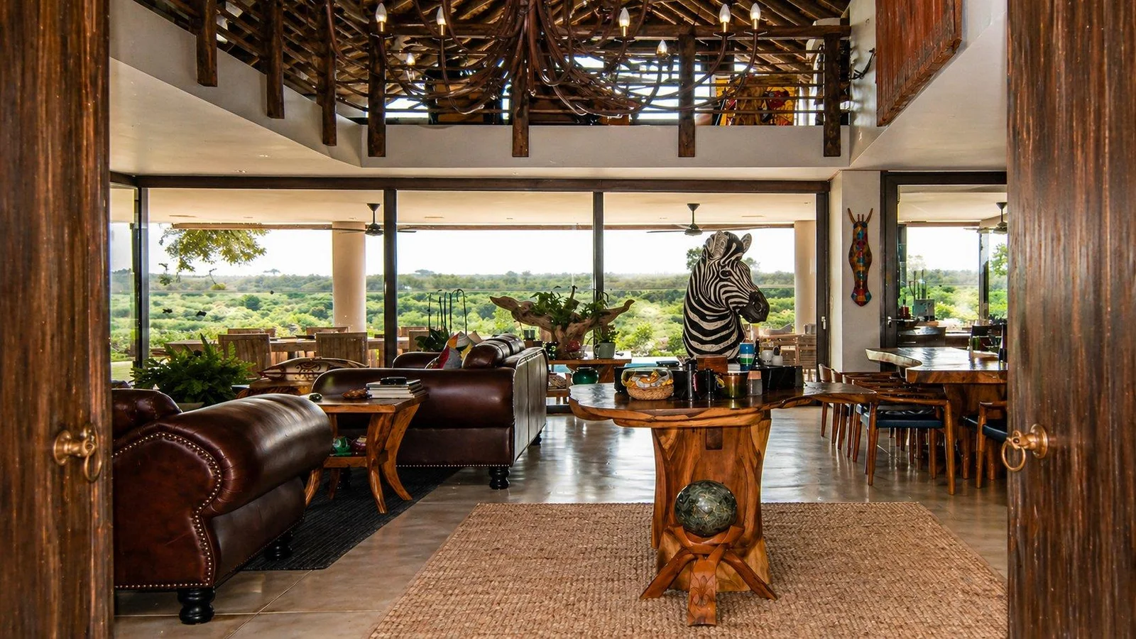 Open-plan living room with double-height glazing and views over the bushveld