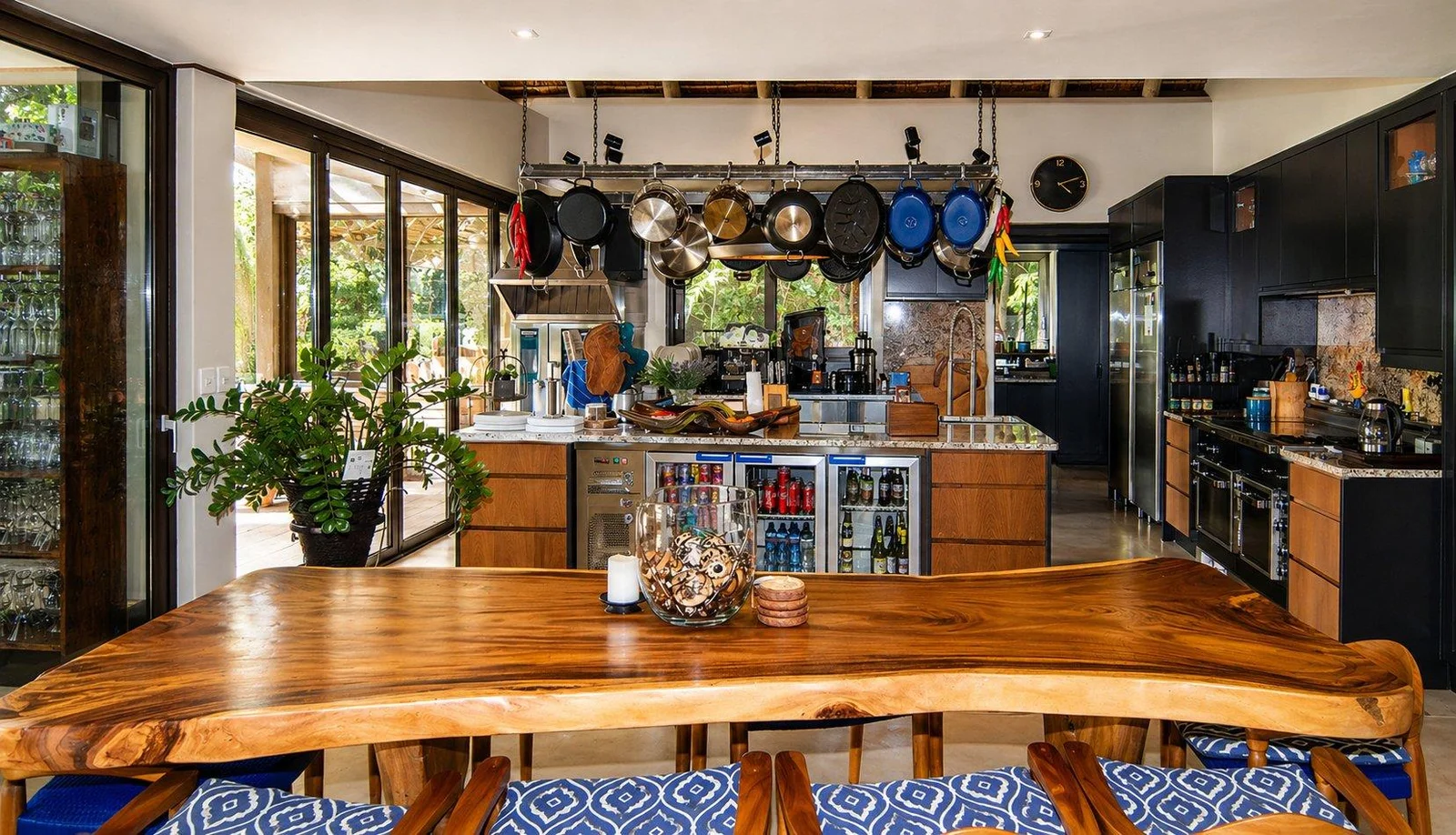 Kitchen with a long timber table and hanging copper pans