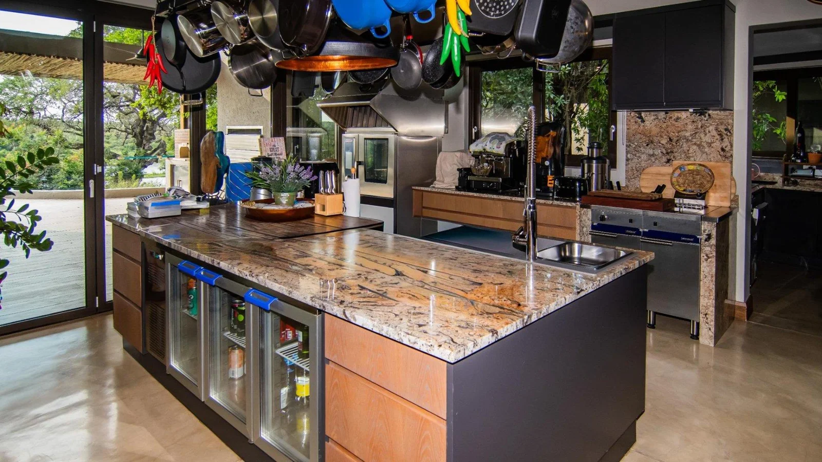 Kitchen with granite island, wine fridges and stainless-steel appliances