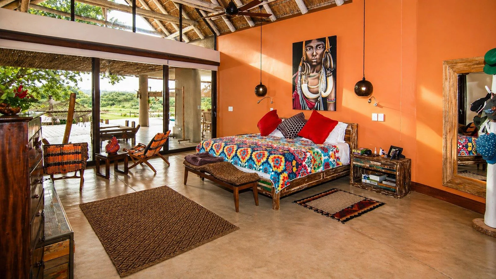 Bedroom with an orange feature wall and doors to the patio