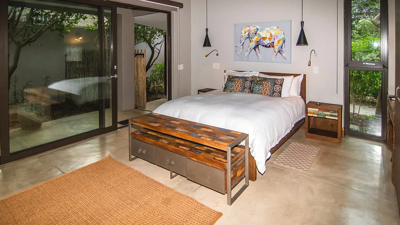 Bedroom with white linen and glazed sliding doors to the garden