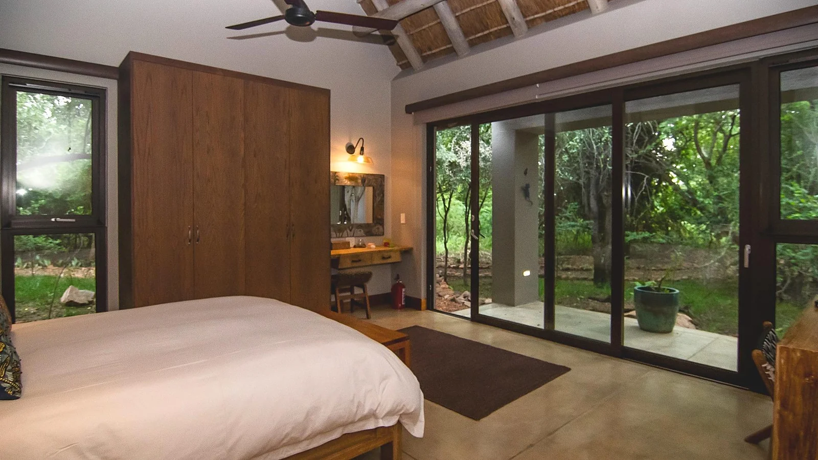 Bedroom with built-in wardrobes and a desk, opening to the garden